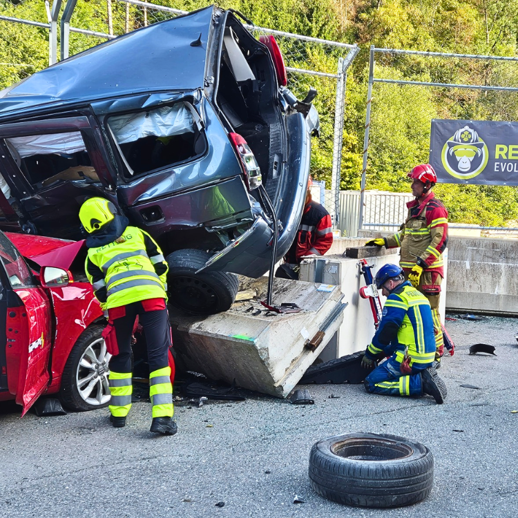 Rettungskräfte begutachten den Crash vom roten Auto und dem Family-Van