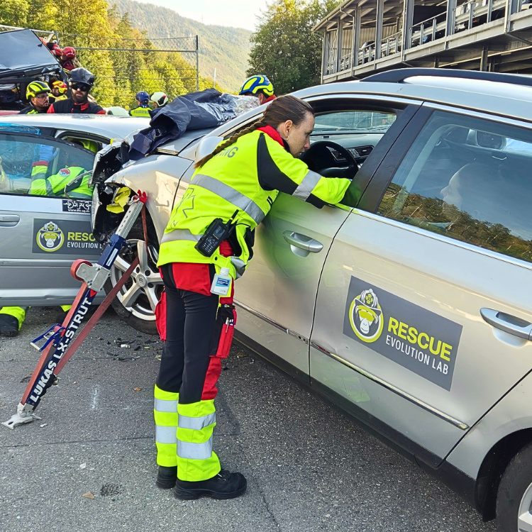Eine Rettungssanitäterin schaut nach der Patientin im Unfallauto. Das Auto ist mit dem LUKAS LX Strut gesichert.