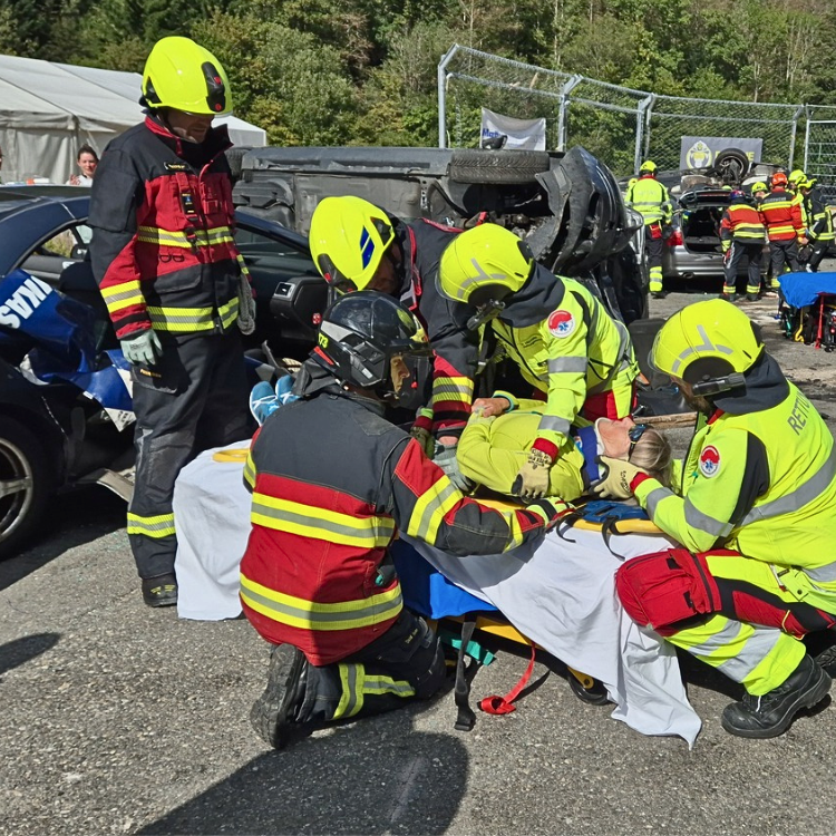 Feuerwehr- und Rettungskräfte bergen eine Patientin aus dem Unfallauto. Die Patientin liegt auf einer Bahre.